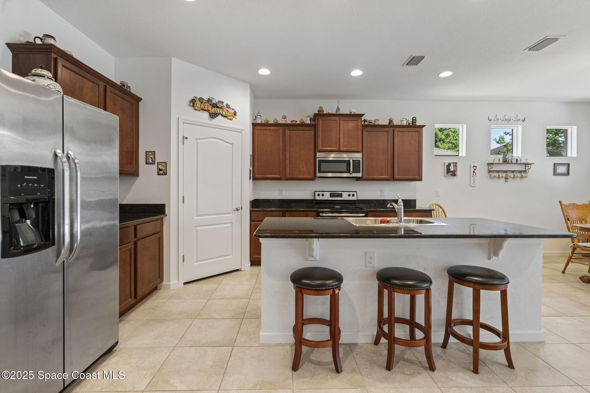 4015 Harvest Circle Rockledge, FL 32955 - Photo 7 of 40 a kitchen with stainless steel appliances a refrigerator and a stove top oven