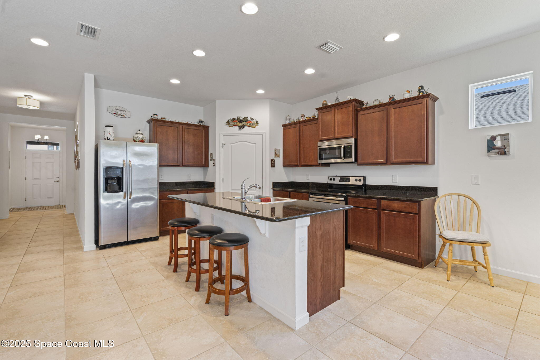 4015 Harvest Circle Rockledge, FL 32955 - Photo 8 of 40 a kitchen with stainless steel appliances granite countertop a stove top oven a sink a refrigerator and a microwave