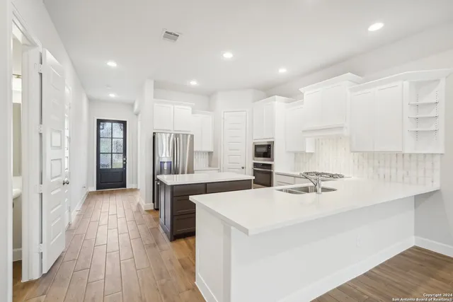 a kitchen with stainless steel appliances a sink stove and refrigerator
