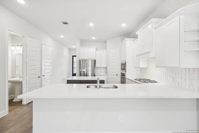 a large kitchen with kitchen island a sink stainless steel appliances and cabinets