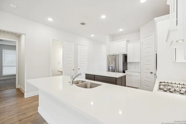 a kitchen with stainless steel appliances a sink and refrigerator