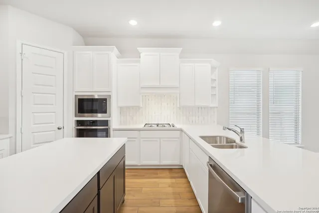 a kitchen with a sink a stove and cabinets