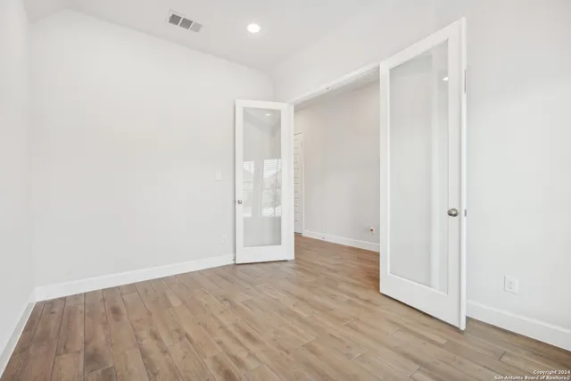 a view of an empty room with wooden floor