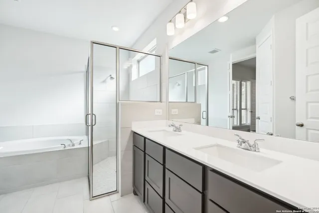 a bathroom with a sink double vanity mirror and a bathtub
