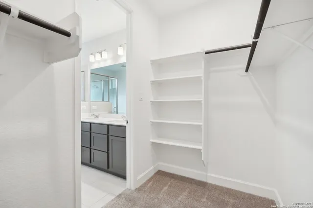 a view of walk in closet with empty racks