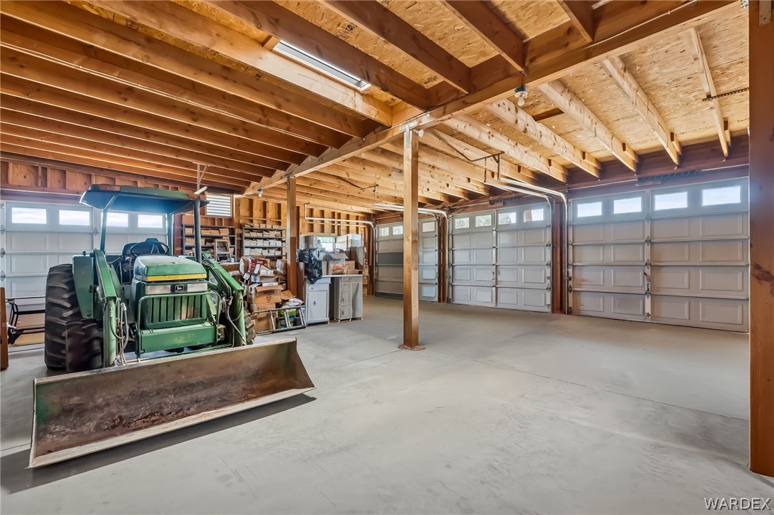 2401 North Stephan Road Kingman, AZ 86401 - Photo 79 of 92 Spacious multi-bay garage featuring exposed wood beam ceilings and multiple overhead garage doors with transom windows