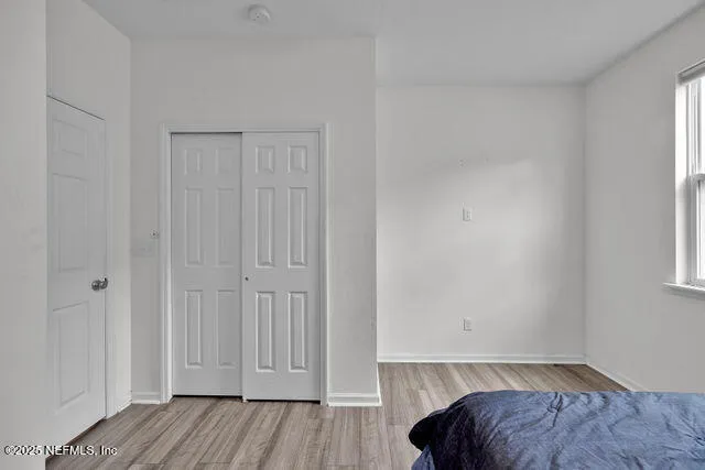 a view of bedroom with a bed and wooden floor