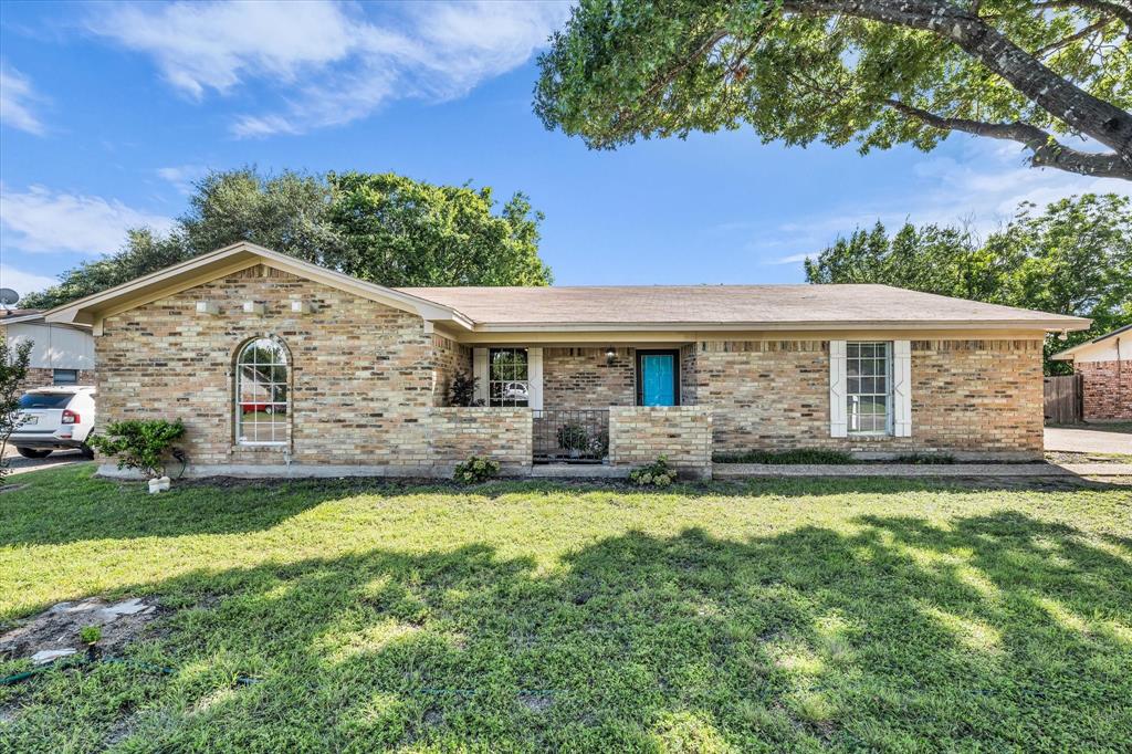 141 Travis Lane Hewitt, TX 76643 - Photo 1 of 31 Brick facade home featuring a prominent arched window, white window shutters, and a vibrant blue entry door