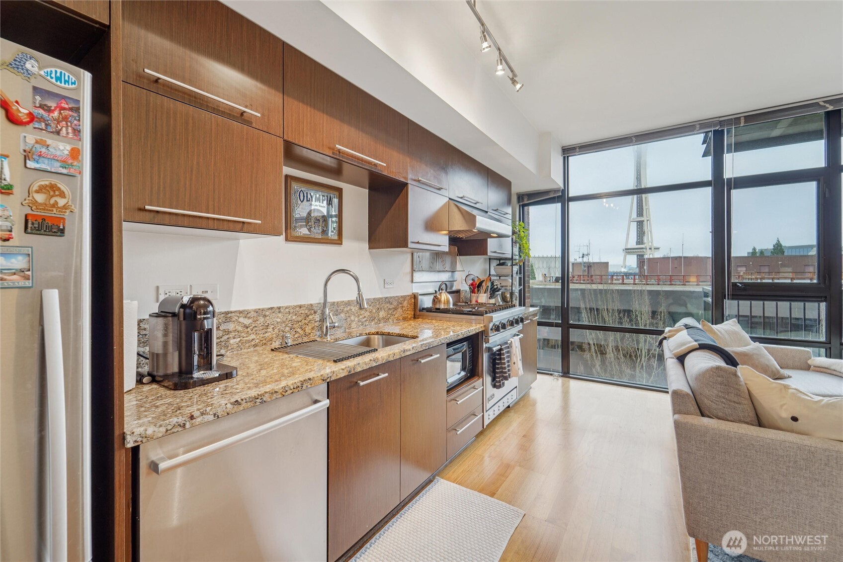 2911 2nd Avenue, Unit 818 Seattle, WA 98121 - Photo 2 of 15 a kitchen with stainless steel appliances granite countertop a sink stove and cabinets