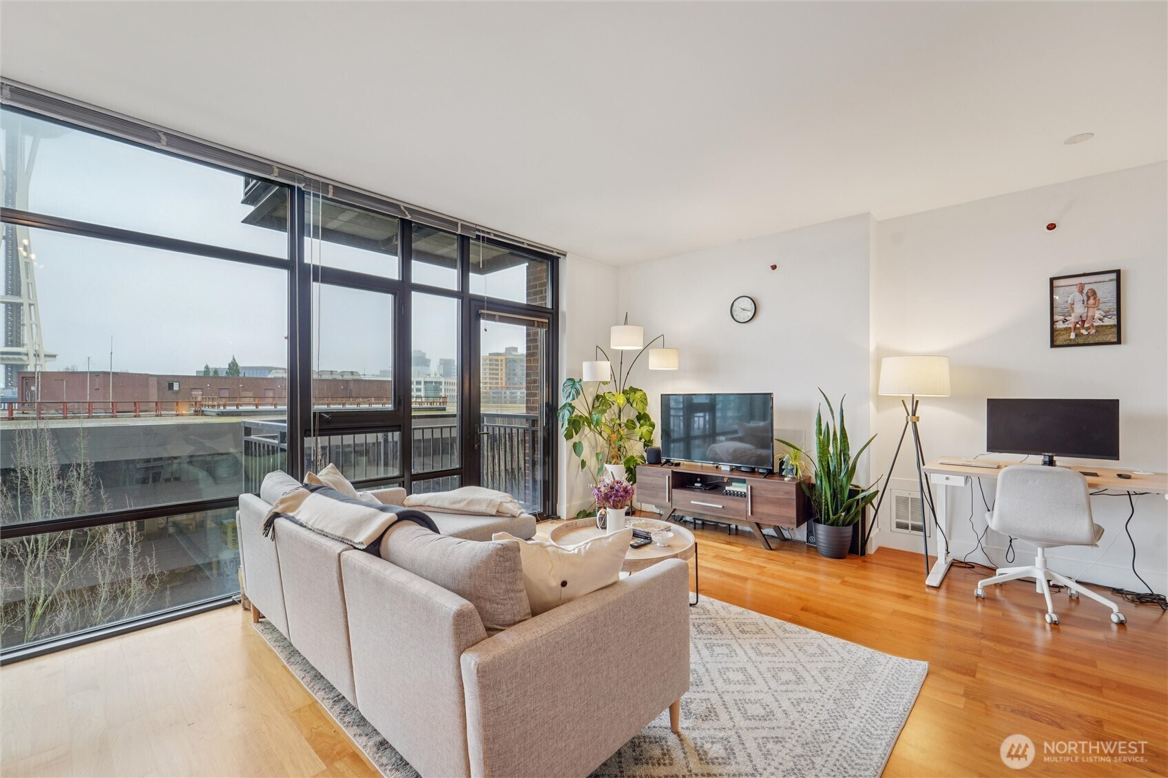 2911 2nd Avenue, Unit 818 Seattle, WA 98121 - Photo 7 of 15 a living room with furniture large windows and a flat screen tv