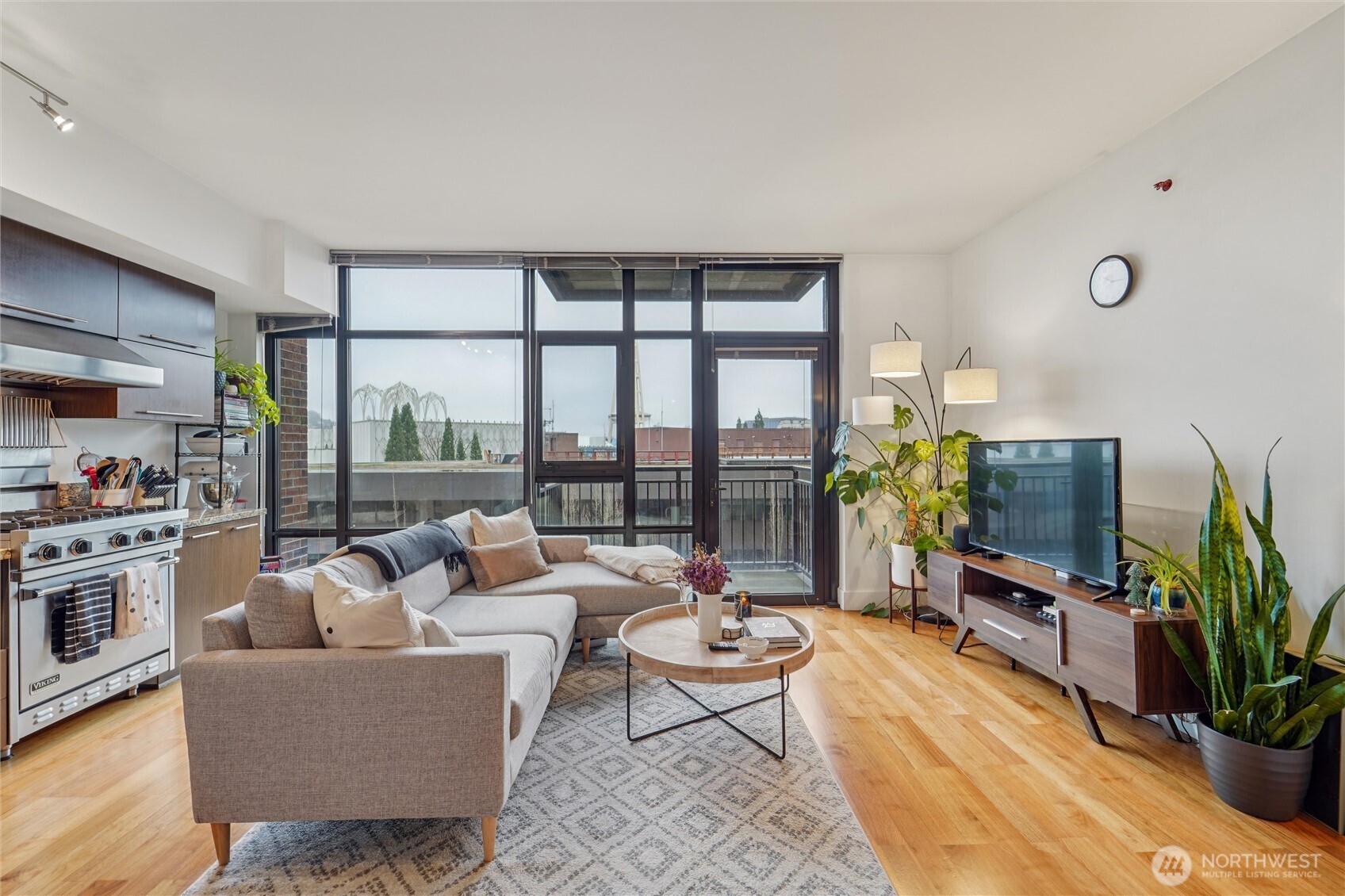 2911 2nd Avenue, Unit 818 Seattle, WA 98121 - Photo 9 of 15 a living room with furniture potted plant and a flat screen tv