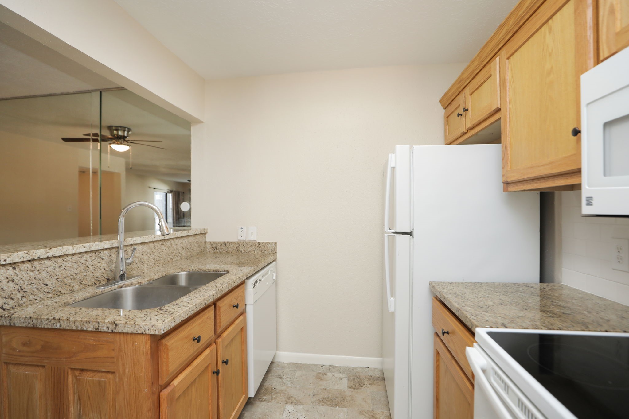 17401 Red Oak Drive, Unit 97 Houston, TX 77090 - Photo 14 of 37 a kitchen with a granite countertop sink and cabinets