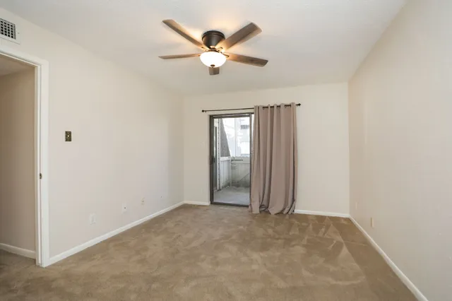 an empty room with fan and windows