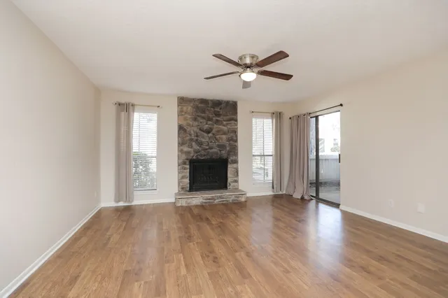 a view of empty room with wooden floor and fireplace