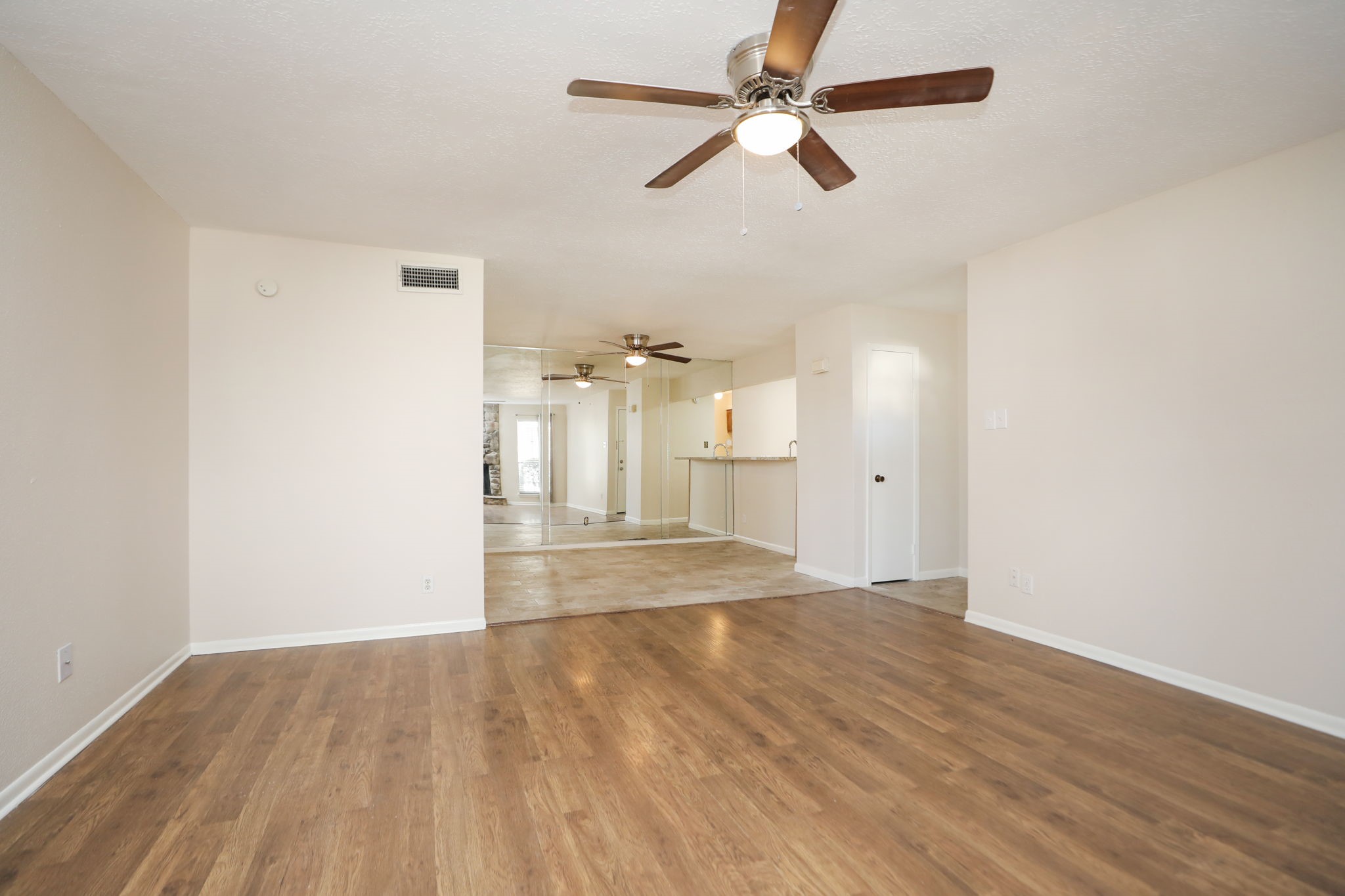 17401 Red Oak Drive, Unit 97 Houston, TX 77090 - Photo 7 of 37 an empty room with wooden floor fan and windows
