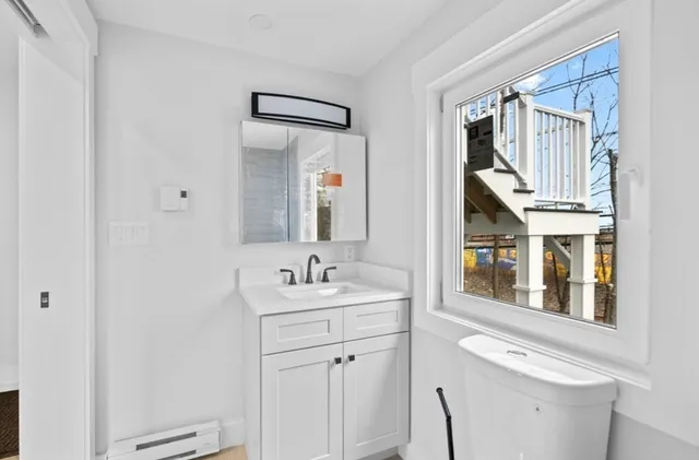 a bathroom with a sink a toilet and mirror