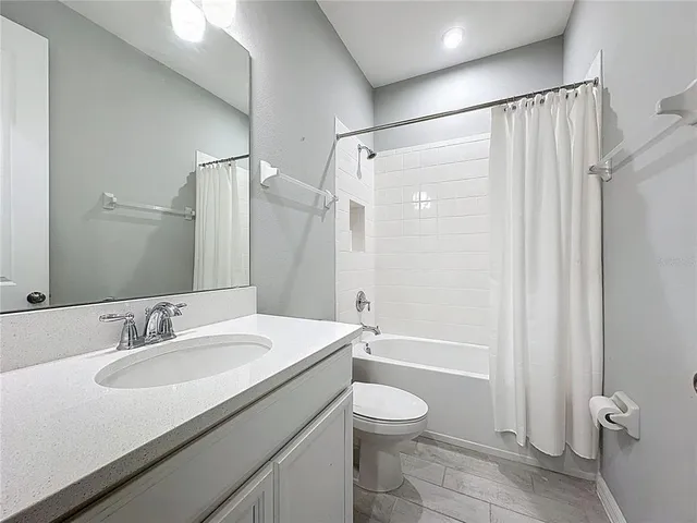 a view of an empty room and chandelier fan