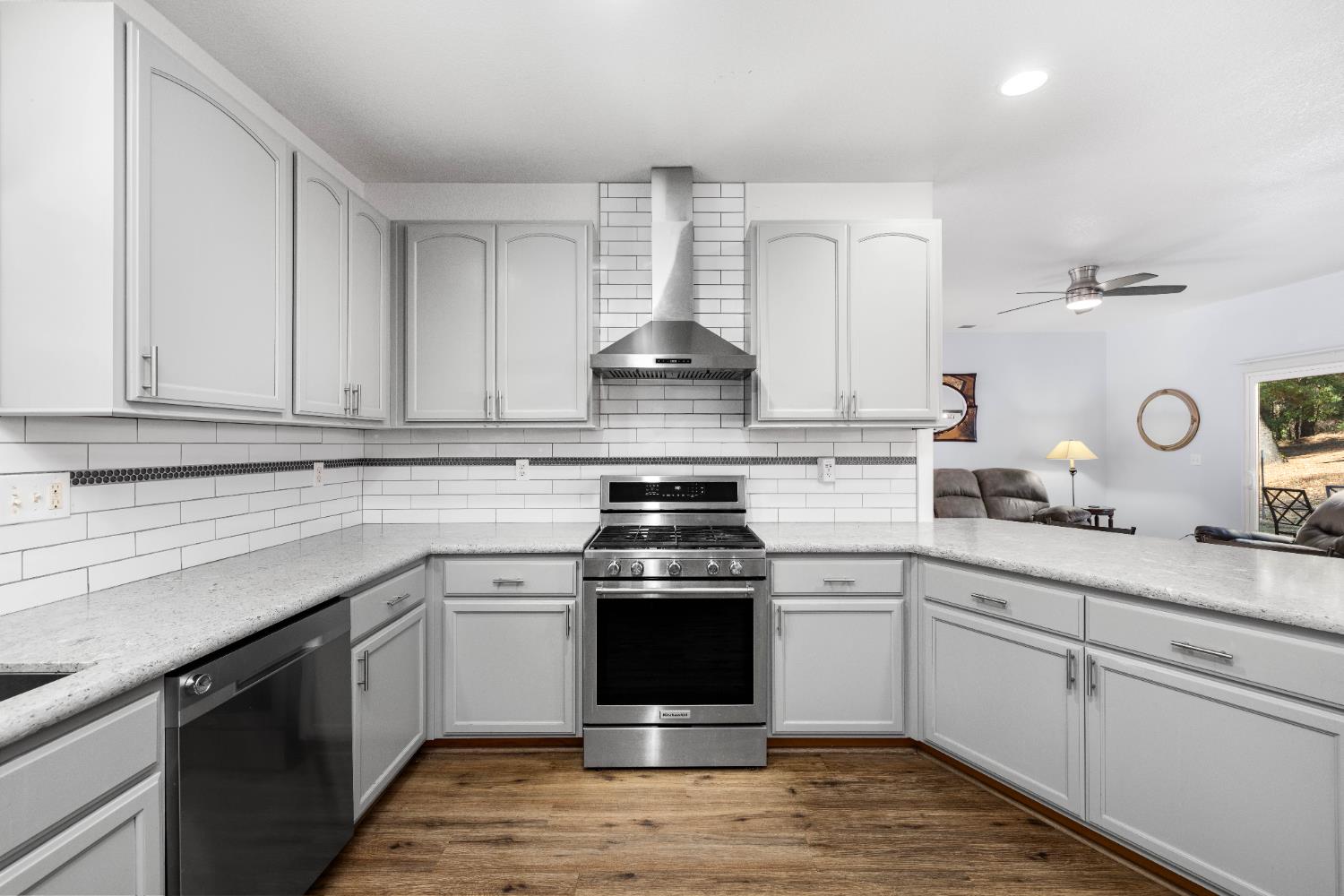 6843 Log Cabin Lane Placerville, CA 95667 - Photo 21 of 49 a kitchen with stainless steel appliances granite countertop a stove and white cabinets
