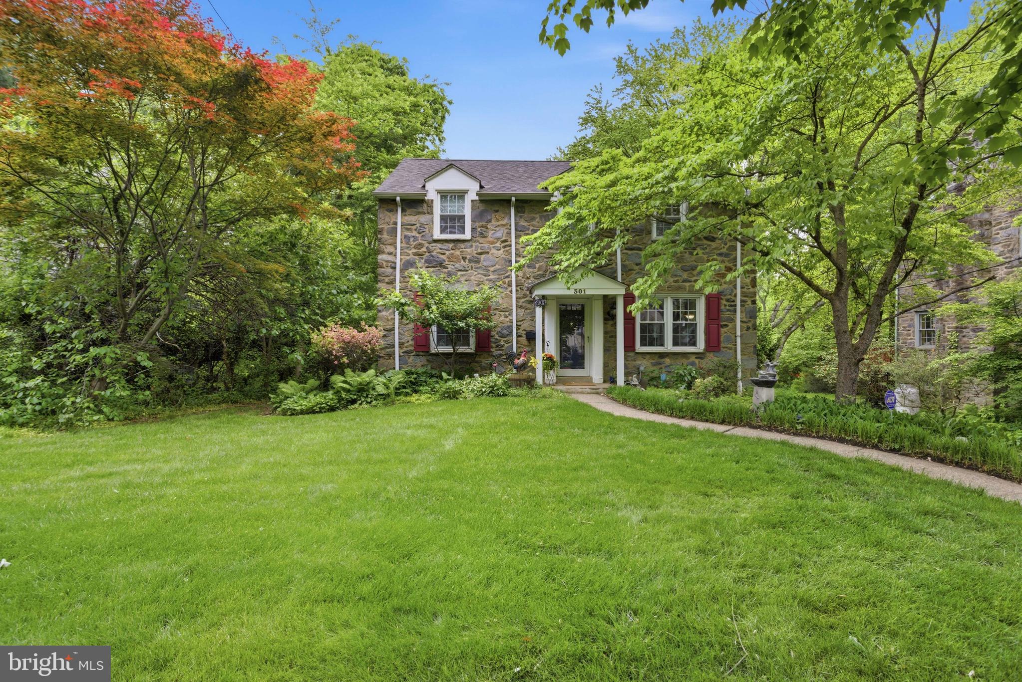 a front view of a house with plants and garden
