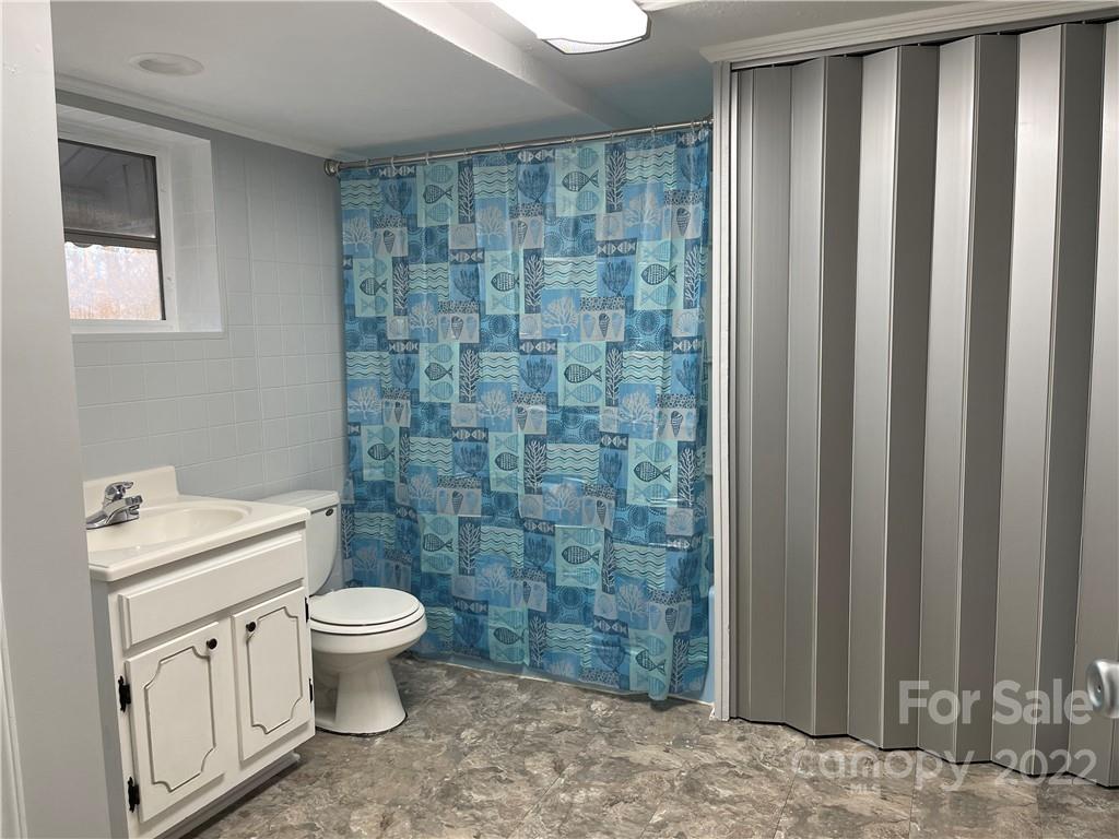 821 Sulphur Springs Road Hiddenite, NC 28636 - Photo 16 of 30 a bathroom with a toilet a sink and a shower