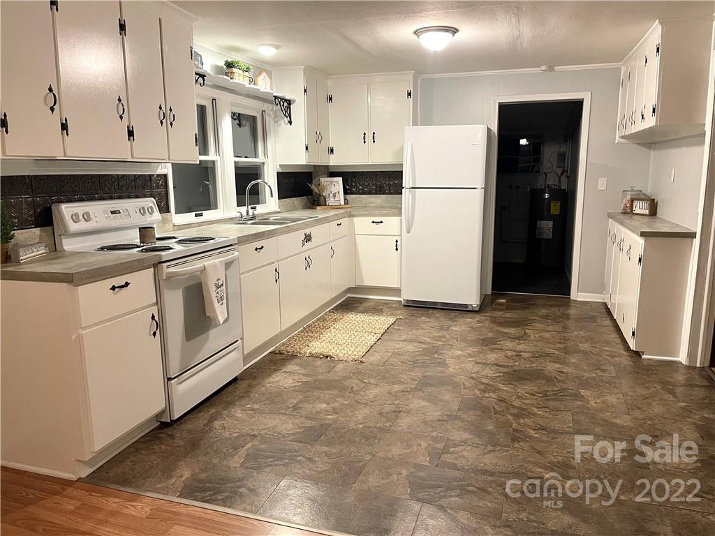 821 Sulphur Springs Road Hiddenite, NC 28636 - Photo 8 of 30 a kitchen with white cabinets and refrigerator