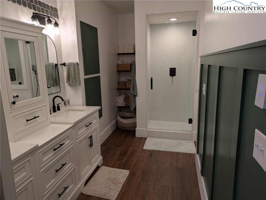 399 Ravens Ridge Circle Boone, NC 28607 - Photo 12 of 42 a spacious bathroom with a double vanity sink a mirror and a shower