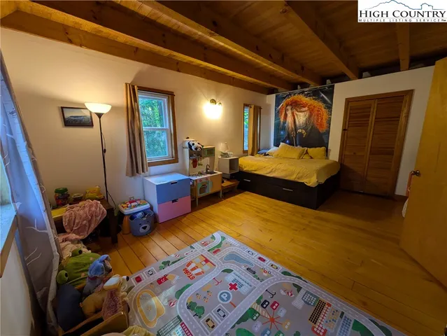 a bedroom with bed and a mirror