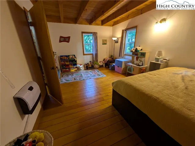 a bedroom with bed and wooden floor