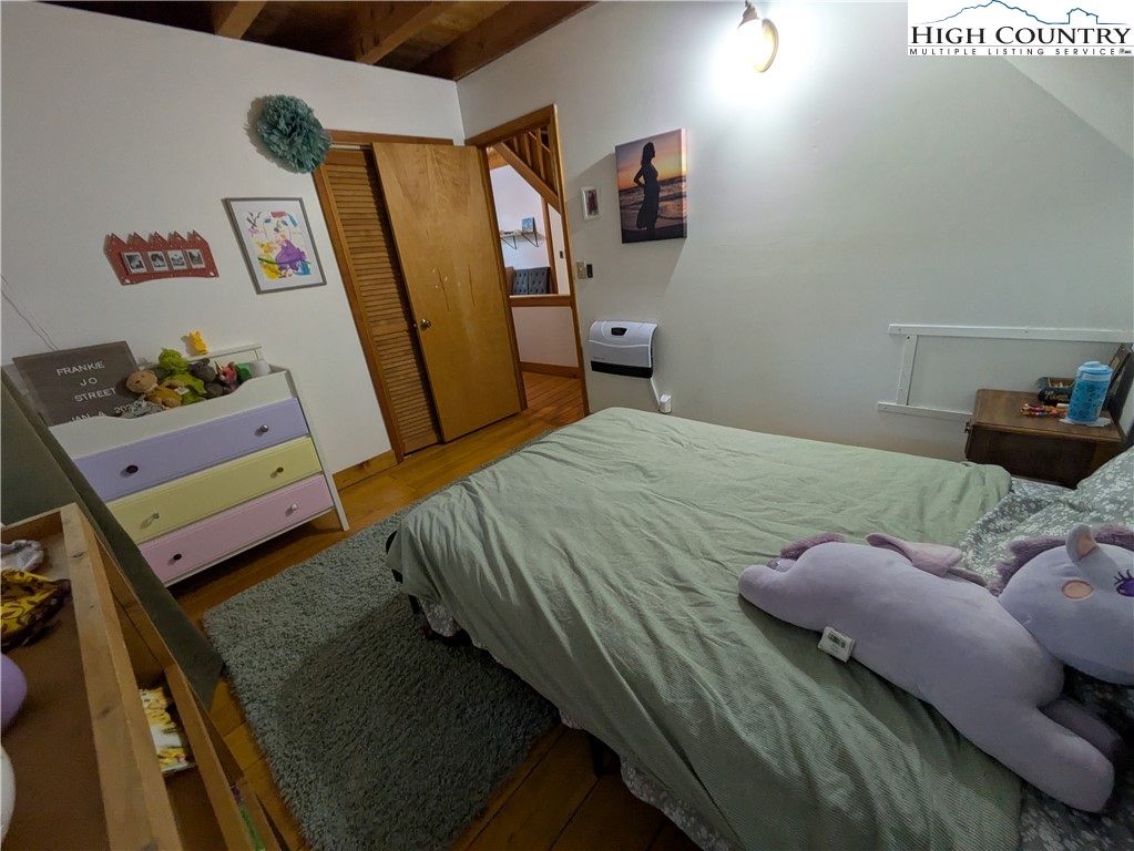399 Ravens Ridge Circle Boone, NC 28607 - Photo 19 of 42 a bedroom with a bed and wooden floor