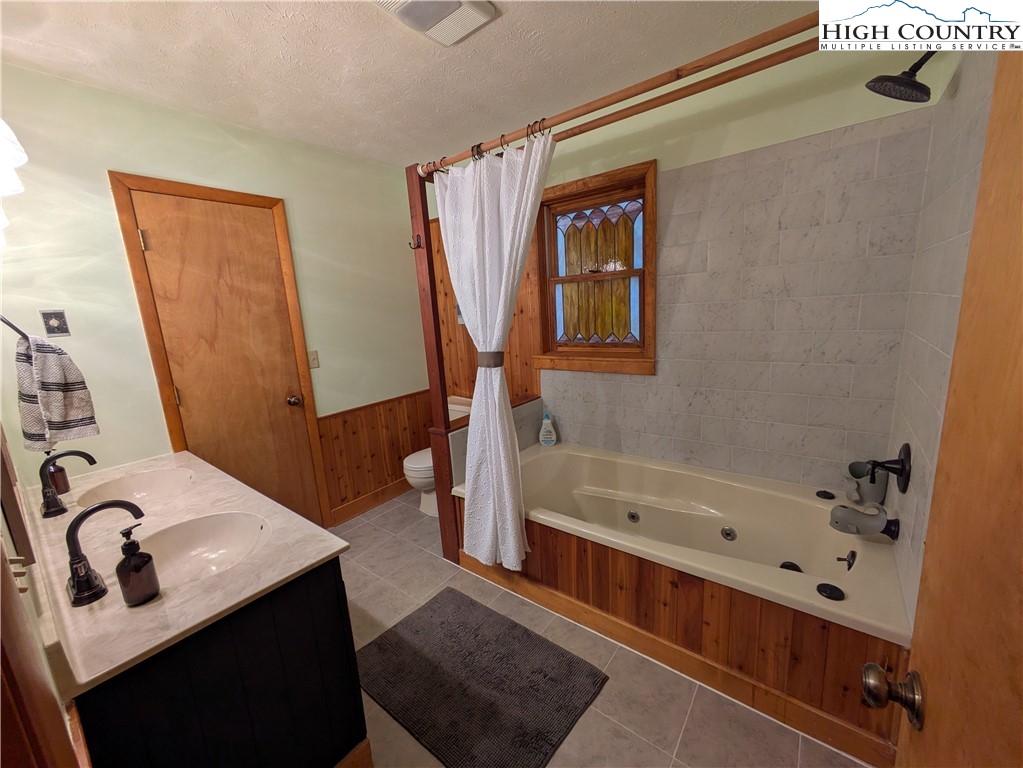 399 Ravens Ridge Circle Boone, NC 28607 - Photo 23 of 42 a bathroom with a bathtub sink and mirror