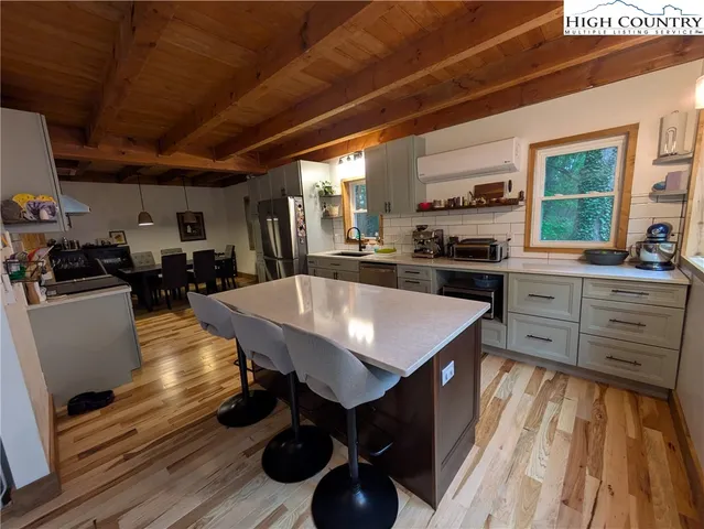 a kitchen with stainless steel appliances granite countertop a sink a stove and a wooden floors