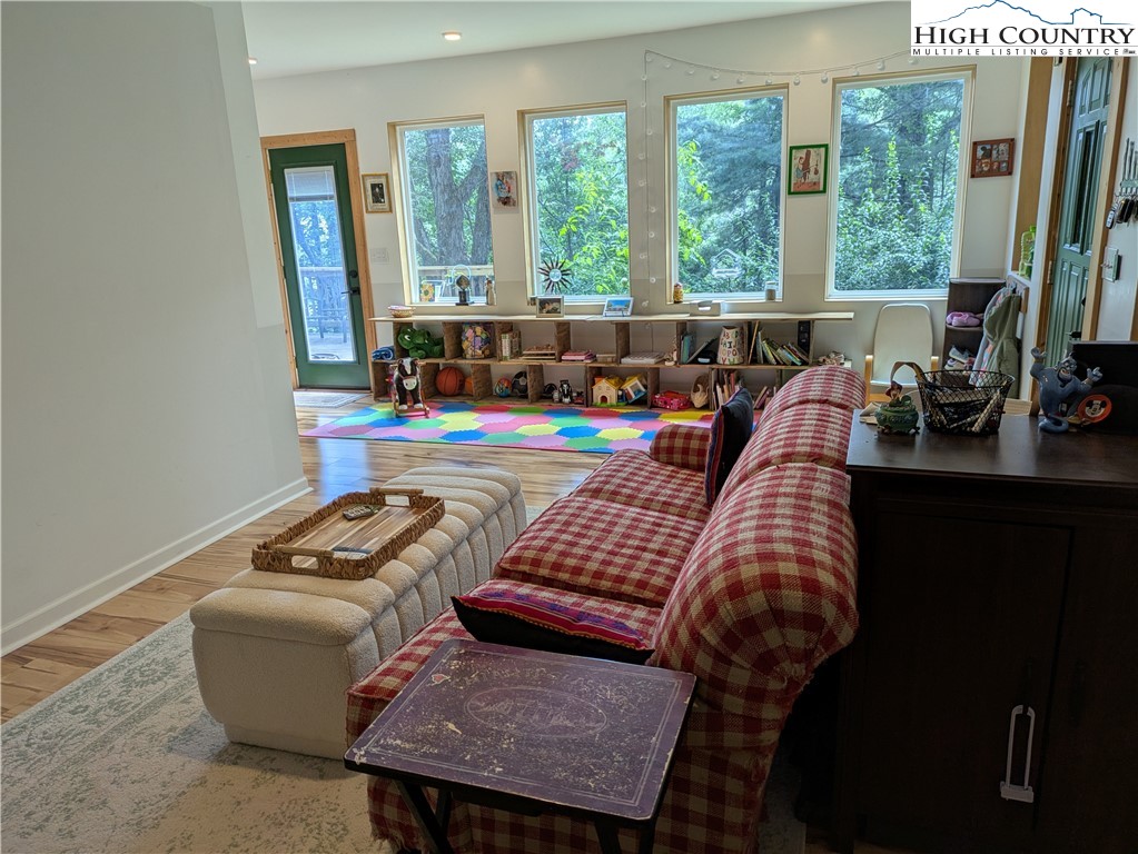 399 Ravens Ridge Circle Boone, NC 28607 - Photo 7 of 42 a living room with furniture and a floor to ceiling window