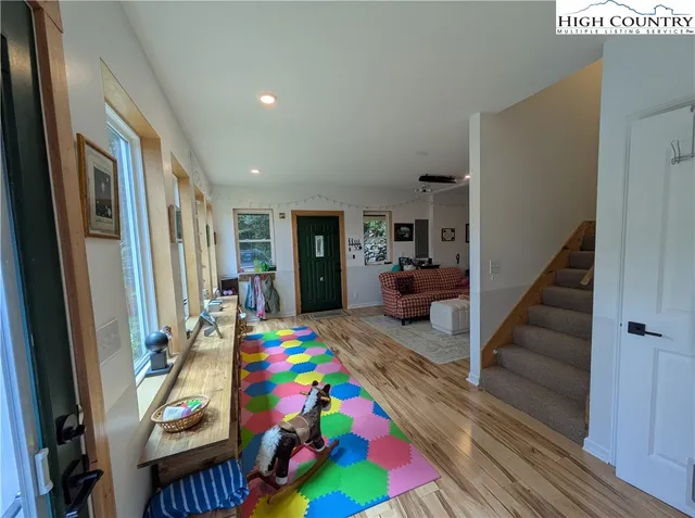 a view of entryway bedroom and hall with wooden floor