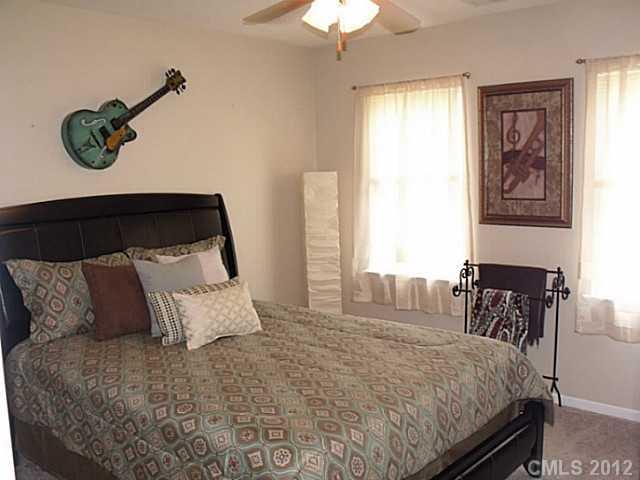 189 Mott Road Mooresville, NC 28115 - Photo 13 of 16 a bedroom with a bed and a chandelier
