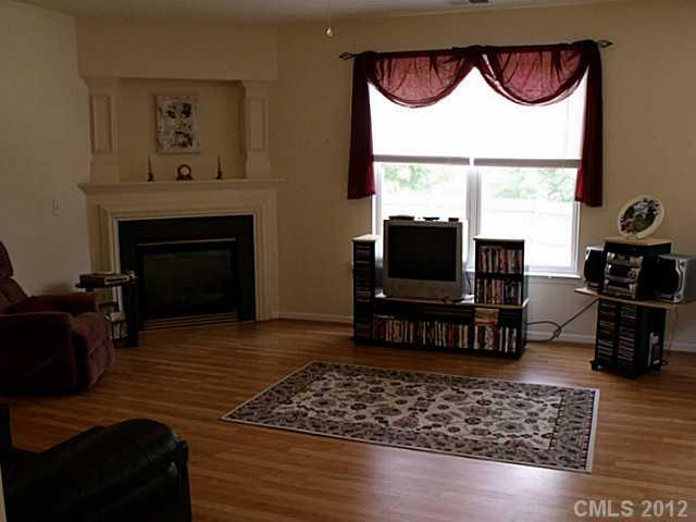 189 Mott Road Mooresville, NC 28115 - Photo 4 of 16 a living room with a fireplace and a flat screen tv
