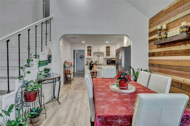 a view of a dining room with furniture a potted plant and wooden floor