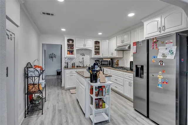 a kitchen with stainless steel appliances refrigerator and cabinets
