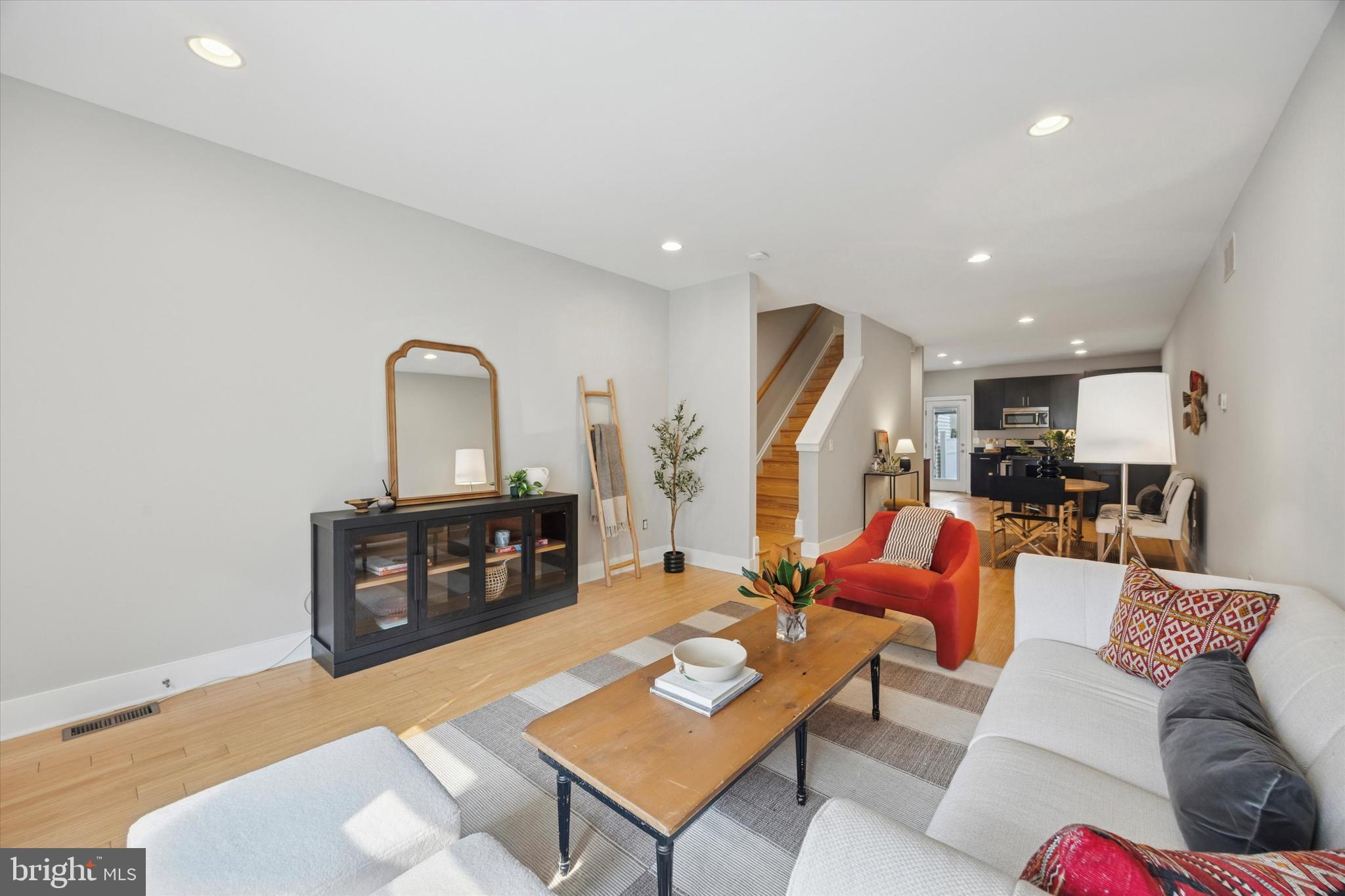 a living room with furniture a couch and kitchen view