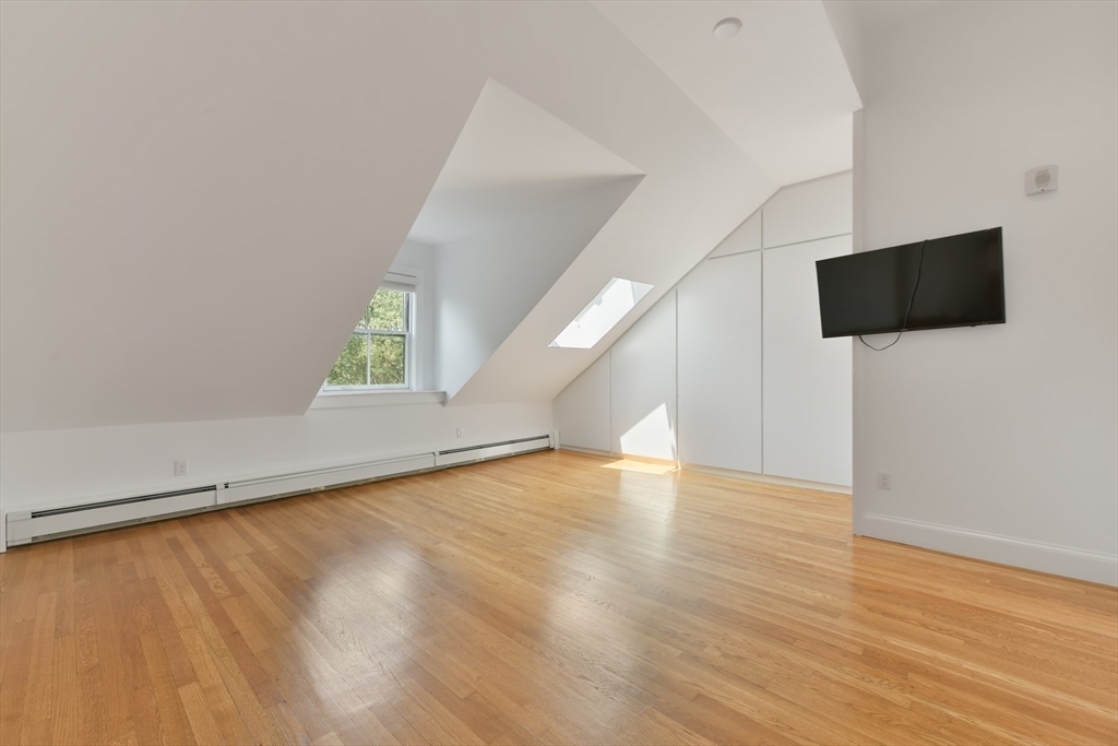 71 Rutland Street, Unit 4 Boston, MA 02118 - Photo 16 of 35 a view of an empty room with wooden floor and a window