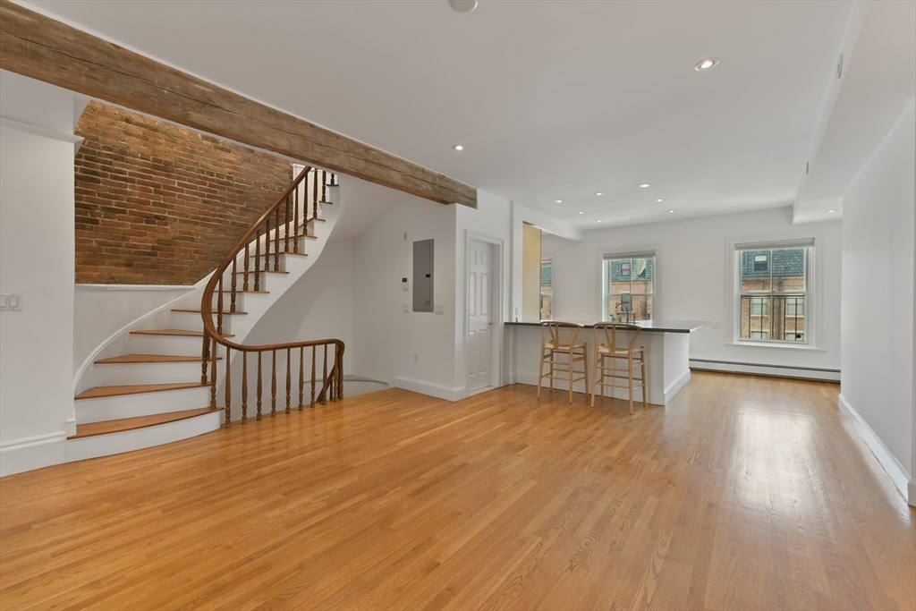 71 Rutland Street, Unit 4 Boston, MA 02118 - Photo 3 of 35 a view of an empty room with wooden floor and a window