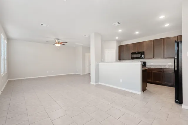 a view of a kitchen with a sink and dishwasher a refrigerator with white cabinets