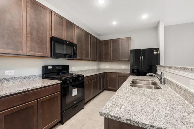 a kitchen with granite countertop wooden cabinets and a stove top oven