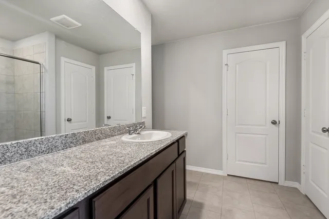 a bathroom with a granite countertop sink and a mirror