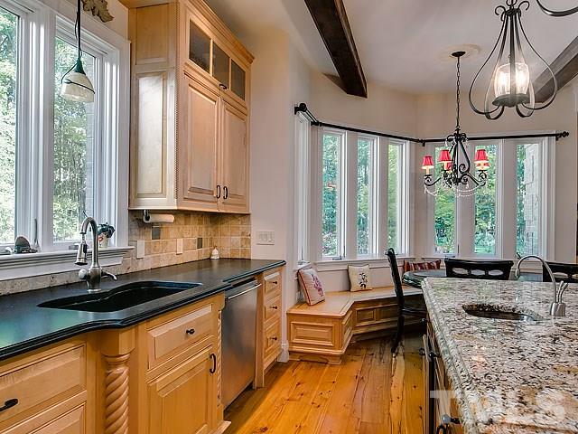 9100 Honeycutt Road Raleigh, NC 27615 - Photo 8 of 25 a kitchen with granite countertop a sink a counter space appliances and cabinets