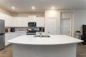 a large kitchen with kitchen island a sink table and chairs
