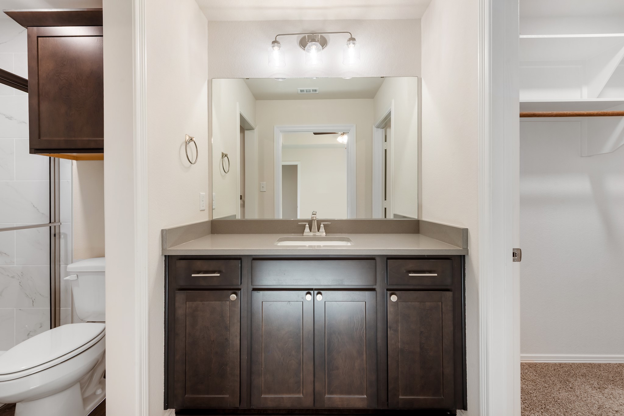 1214 High Street Navasota, TX 77868 - Photo 23 of 28 a bathroom with a granite countertop sink a toilet and a mirror