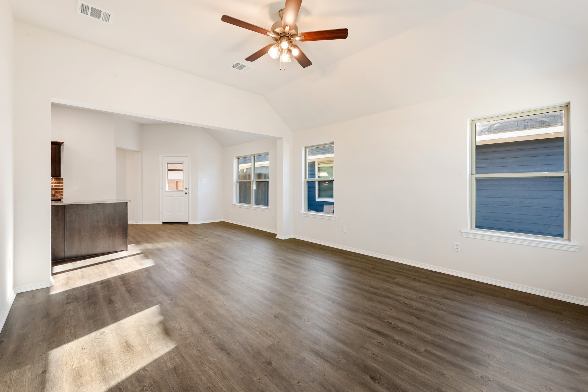 1214 High Street Navasota, TX 77868 - Photo 5 of 28 a view of a livingroom with wooden floor a ceiling fan and windows