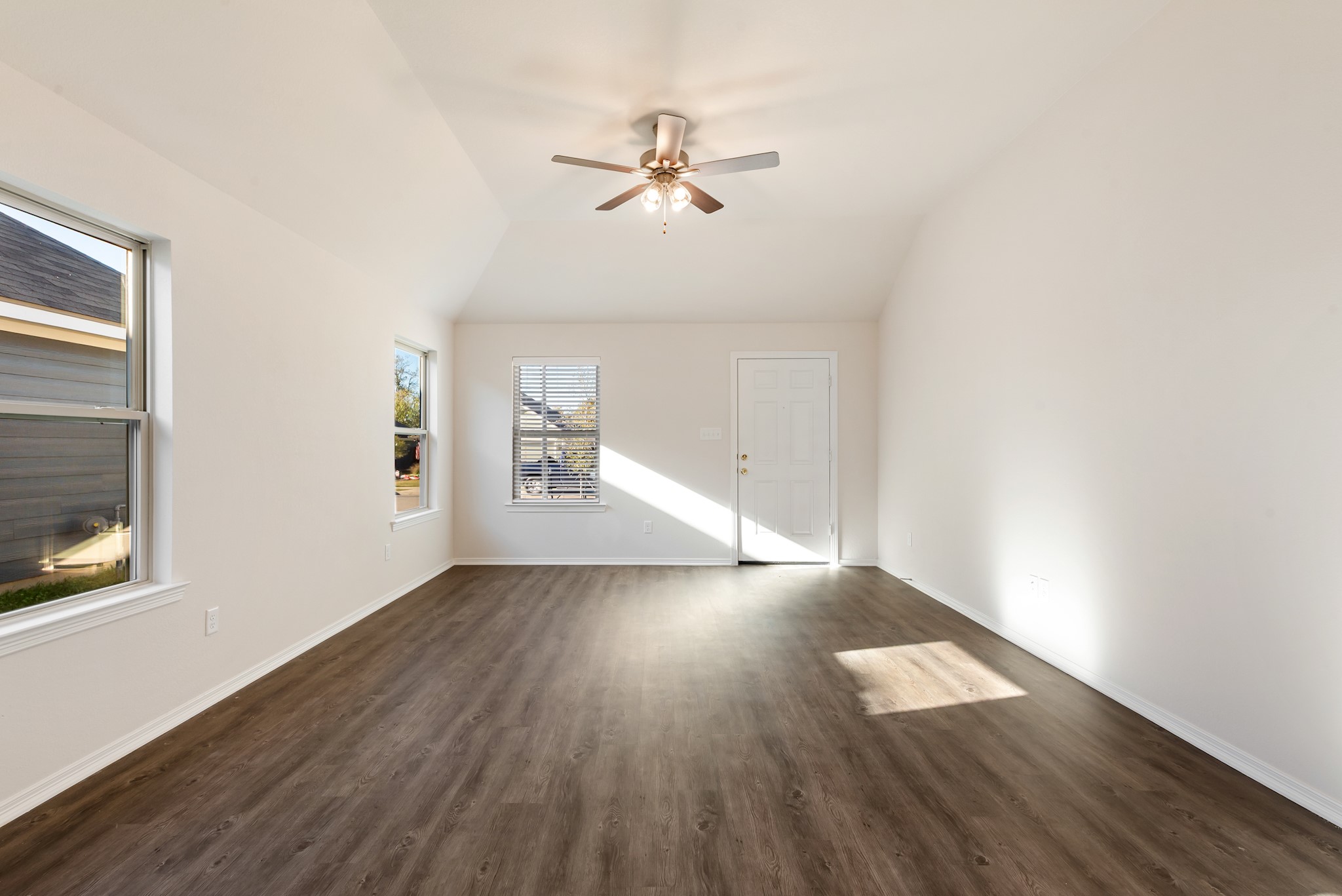 1214 High Street Navasota, TX 77868 - Photo 7 of 28 an empty room with wooden floor chandelier fan and windows