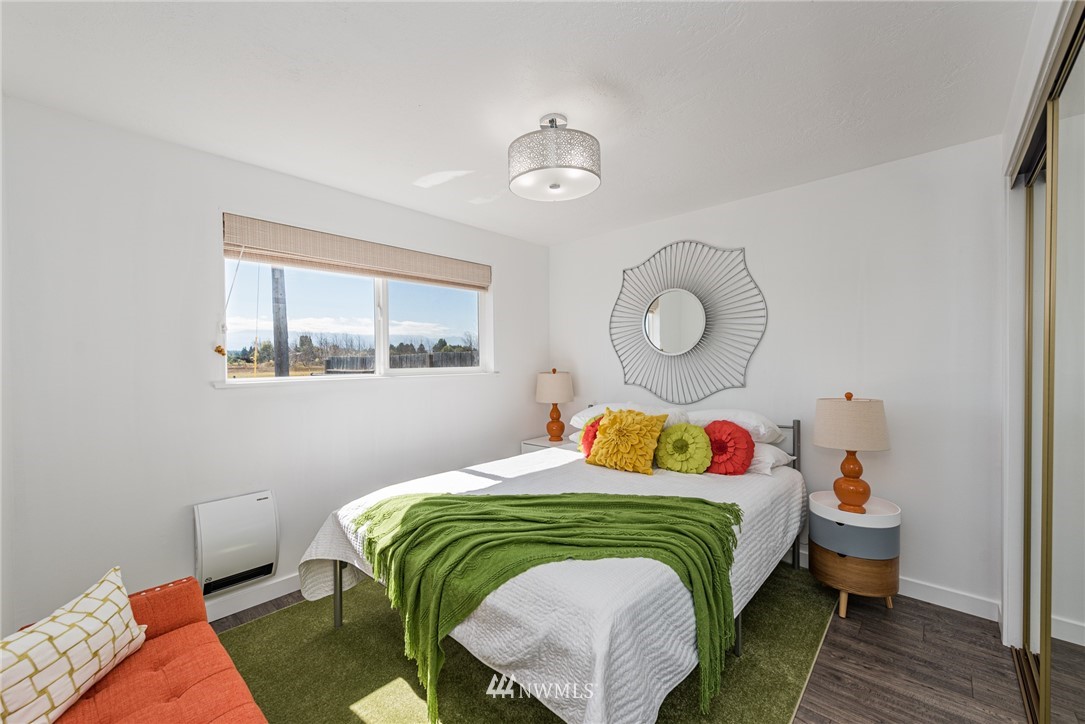 271 3 Crabs Road Sequim, WA 98382 - Photo 15 of 40 a bedroom with a bed and wooden floor