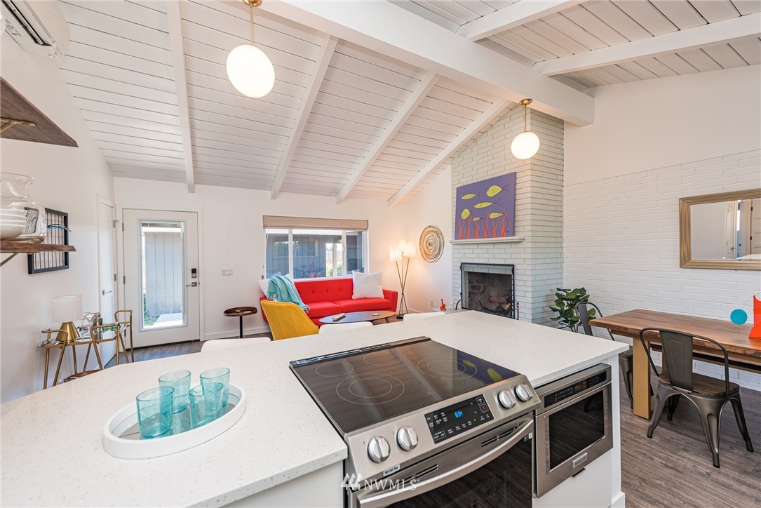 271 3 Crabs Road Sequim, WA 98382 - Photo 33 of 40 a living room with a fireplace a dining table and chairs with wooden floor